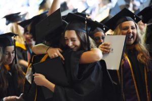 Two students hug at commencement