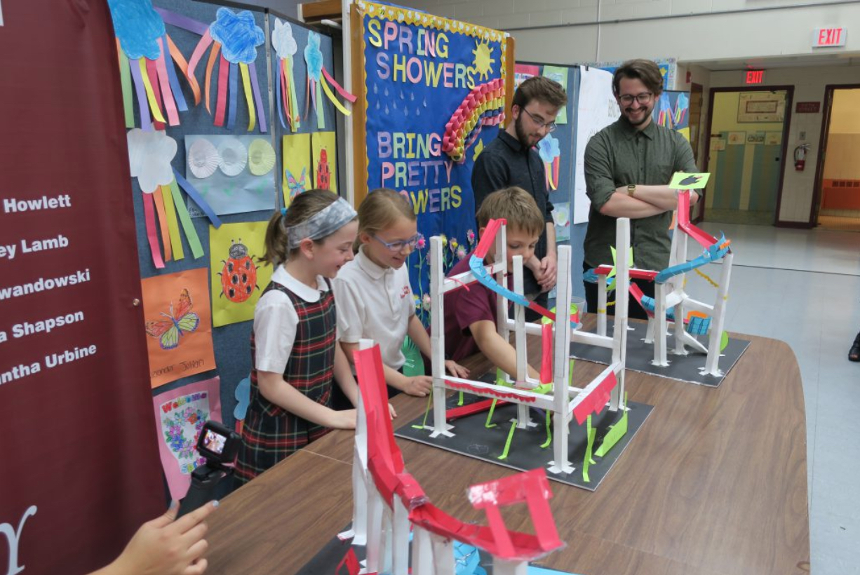 Three students demo their homemade roller coasters