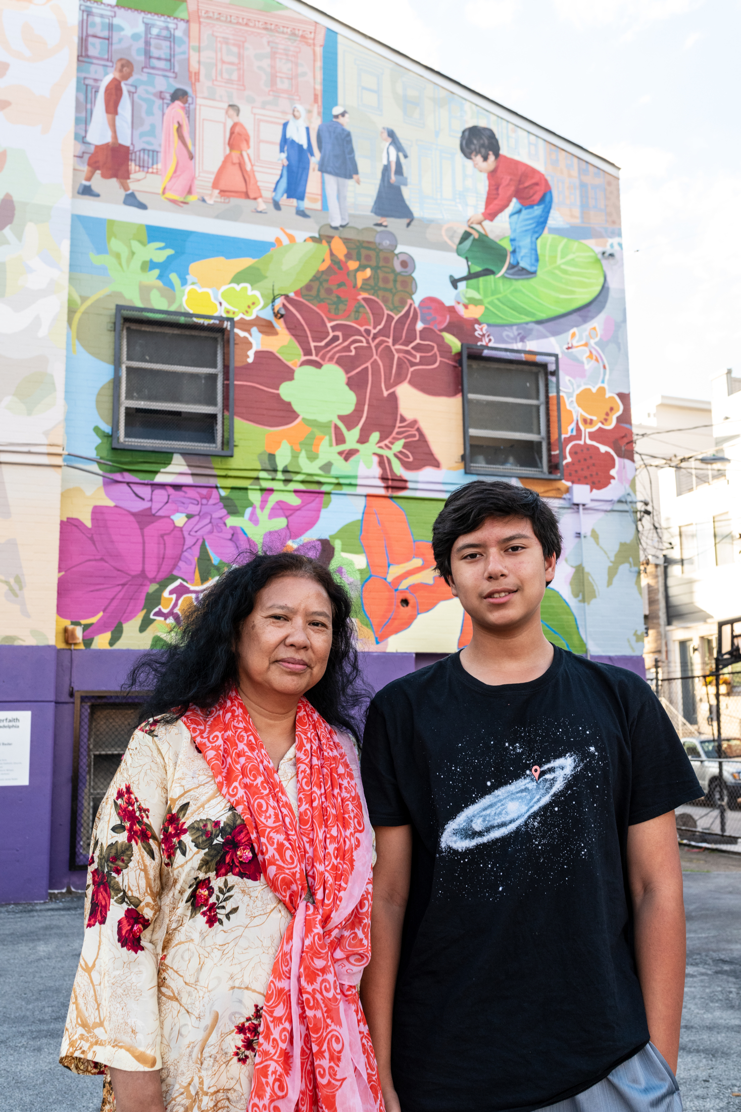 Rashidah Salam and her son pose in front of the mural