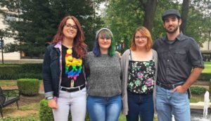 Four members of the Queer Student Union standing outside