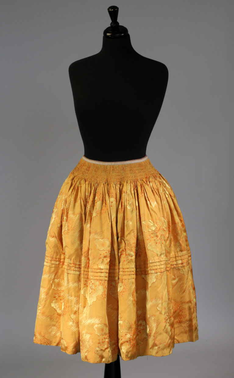 Knee-length skirt with numerous tiny cartridge pleats at the waist and a series of four narrow horizontal tucks midway down the skirt. Worn by Aymara women of the Andean Highlands. Mid-20th century.