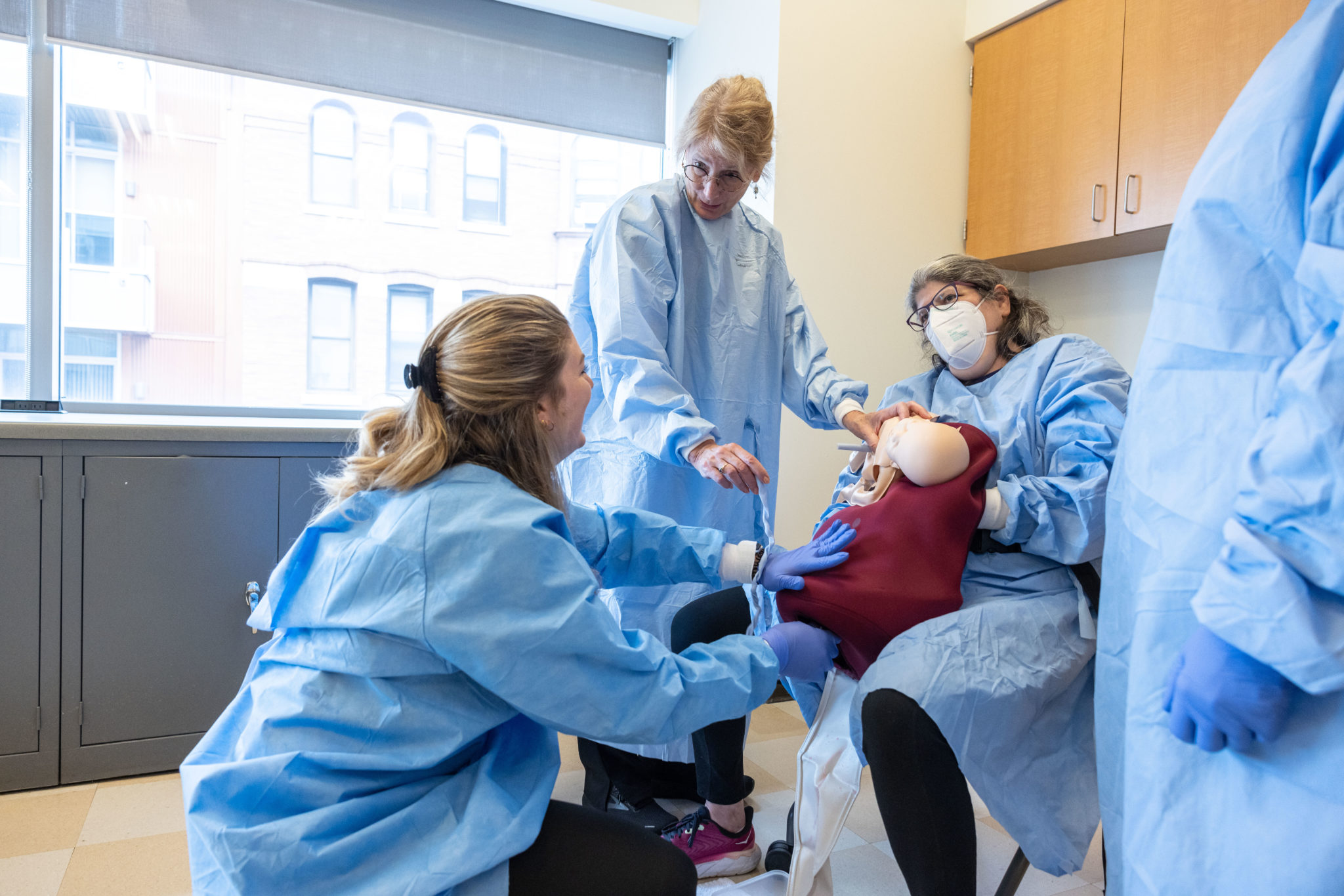 Faculty and students learning birth skills in simulation during an on-campus intensive.