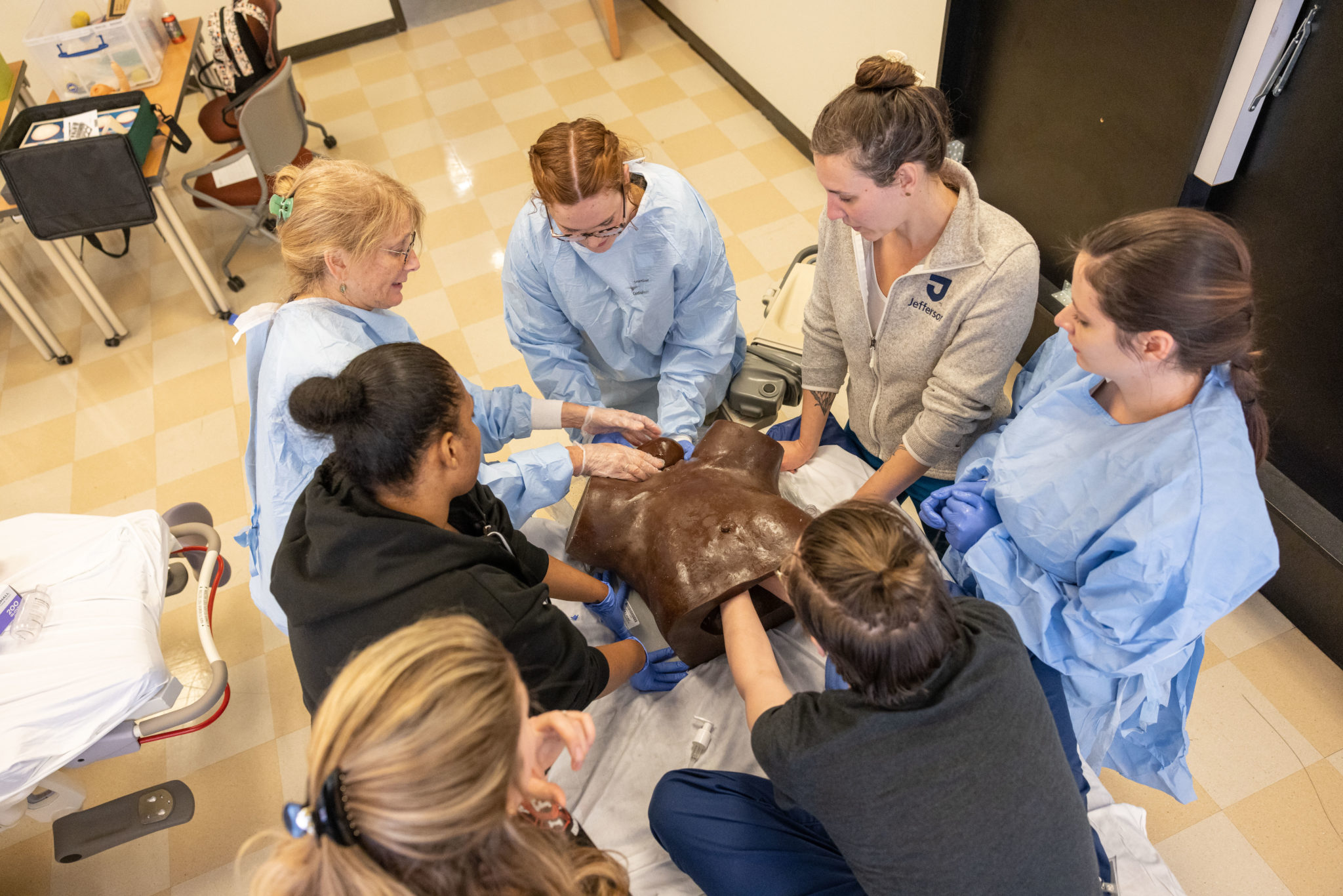 Faculty and students learning birth skills in simulation during an on-campus intensive.